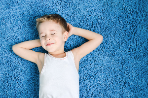 child laying on cleaned carpet
